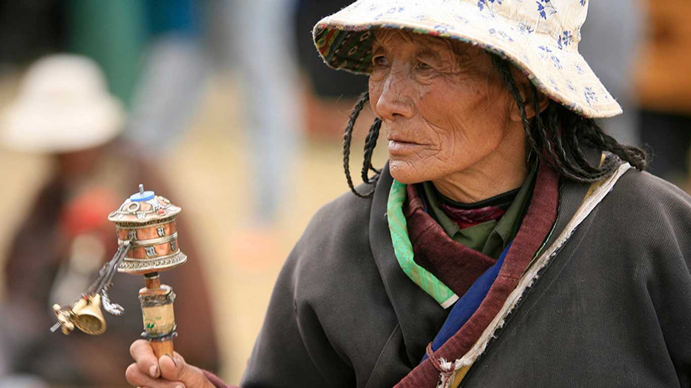 A Local Tibetan Women with Her Prayer Wheel on Hand in Lhasa